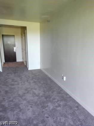 spare room with dark carpet