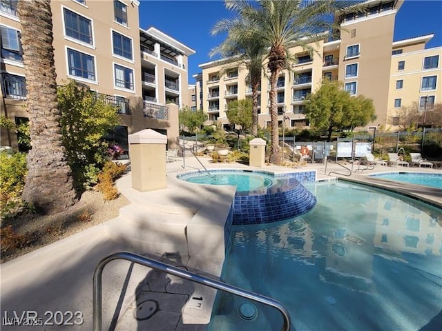 community pool with a community hot tub, a patio, and fence