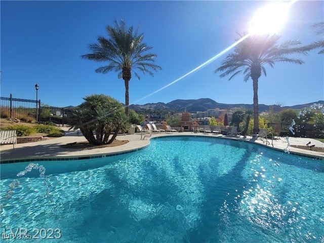 community pool with fence and a mountain view