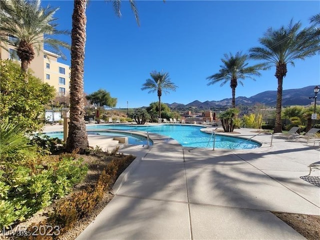 community pool with a patio area and a mountain view