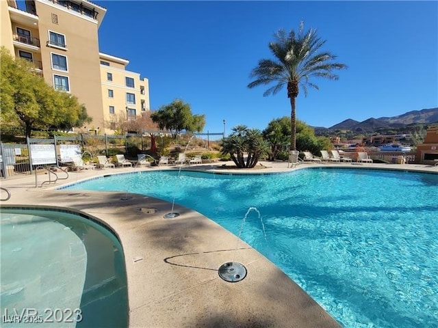 community pool with fence and a mountain view