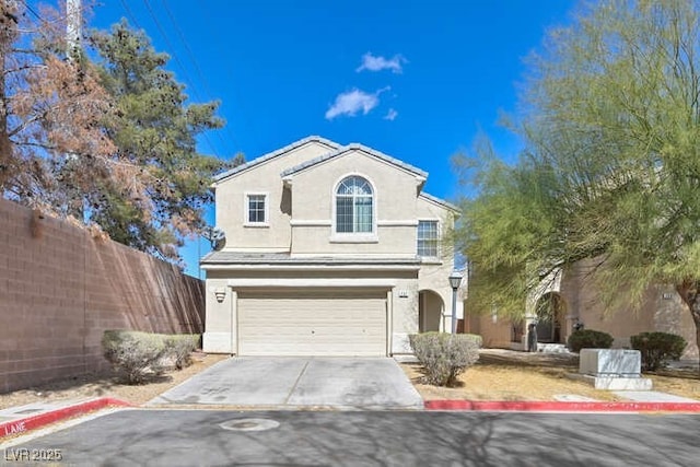 traditional-style home with driveway, a garage, fence, and stucco siding