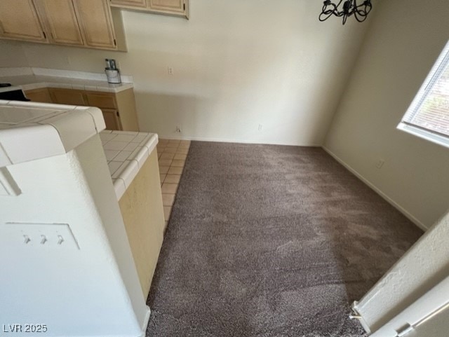 interior space featuring tile counters and light colored carpet