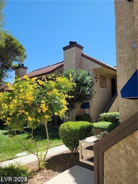 exterior space featuring a tiled roof, a chimney, and stucco siding