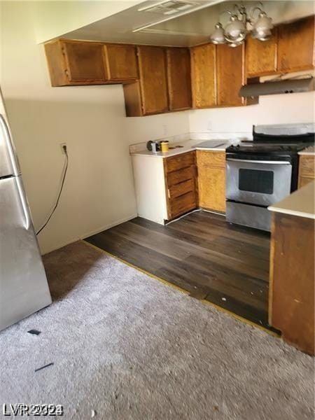 kitchen featuring stainless steel appliances, brown cabinets, light countertops, and under cabinet range hood