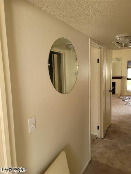 hallway with a textured ceiling