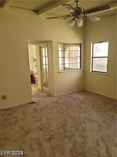 empty room featuring a ceiling fan, carpet, and baseboards