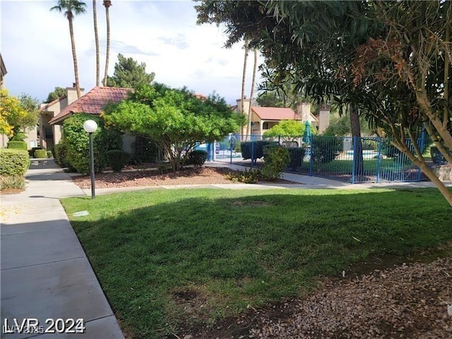 surrounding community with fence and a lawn