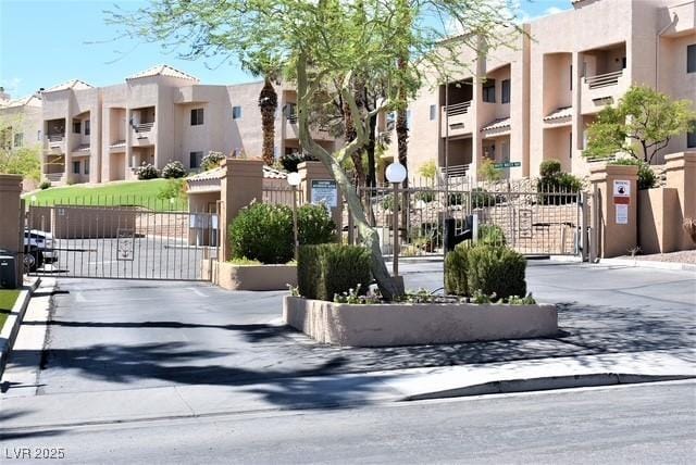 view of road with a residential view, a gate, and a gated entry