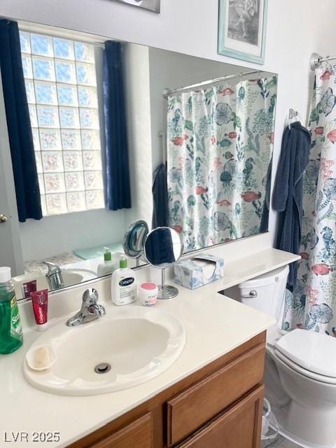 full bath featuring toilet, vanity, and a wealth of natural light