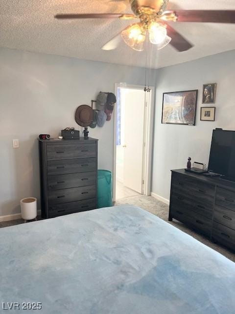 bedroom featuring a ceiling fan, carpet, baseboards, and a textured ceiling