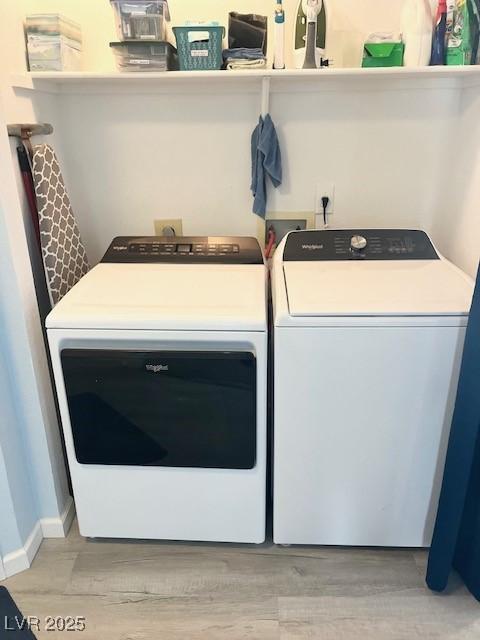 clothes washing area featuring laundry area, baseboards, washer and clothes dryer, and light wood finished floors