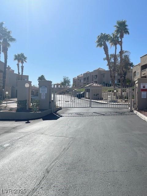 view of road with a residential view, a gate, and a gated entry