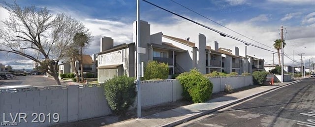 exterior space featuring a residential view and fence