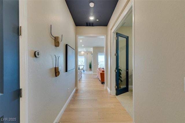 hallway with light wood-type flooring, visible vents, baseboards, and recessed lighting