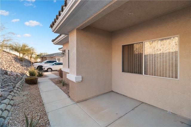 view of side of home featuring a patio area and stucco siding