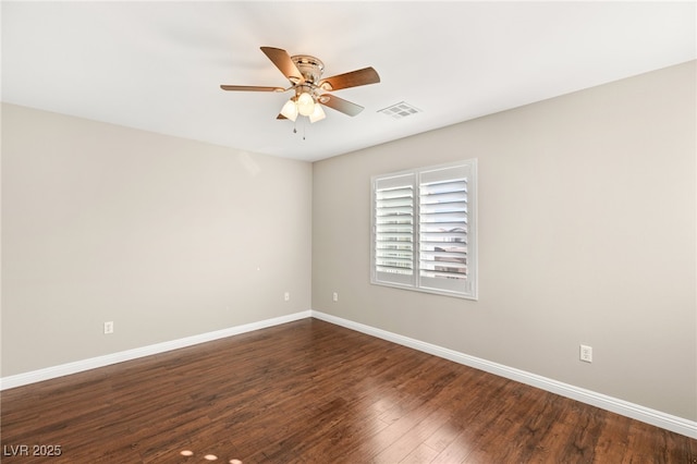 unfurnished room with dark wood-style floors, visible vents, ceiling fan, and baseboards