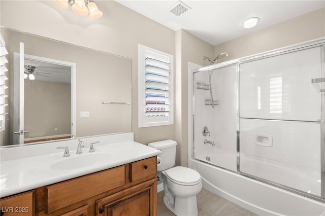 bathroom featuring visible vents, toilet, combined bath / shower with glass door, vanity, and tile patterned floors