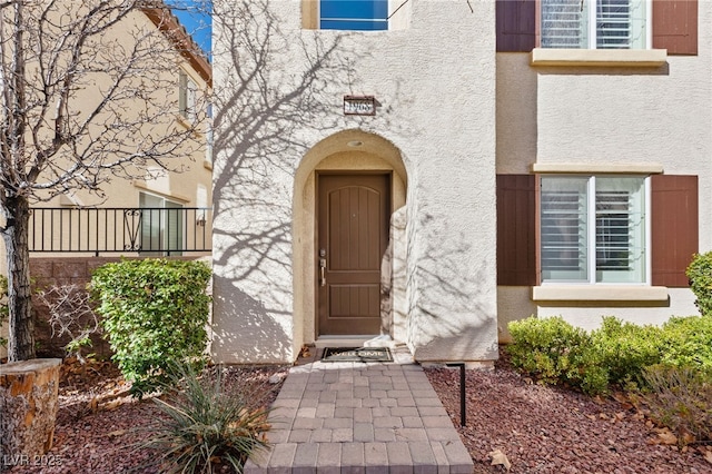 doorway to property with a balcony and stucco siding