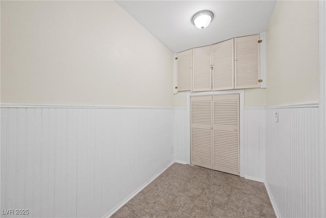 unfurnished bedroom featuring a closet and wainscoting