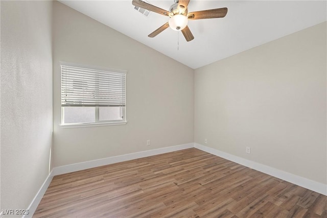 unfurnished room featuring lofted ceiling, visible vents, baseboards, and wood finished floors