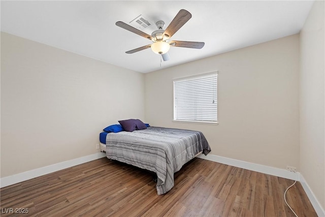 bedroom featuring visible vents, wood finished floors, a ceiling fan, and baseboards