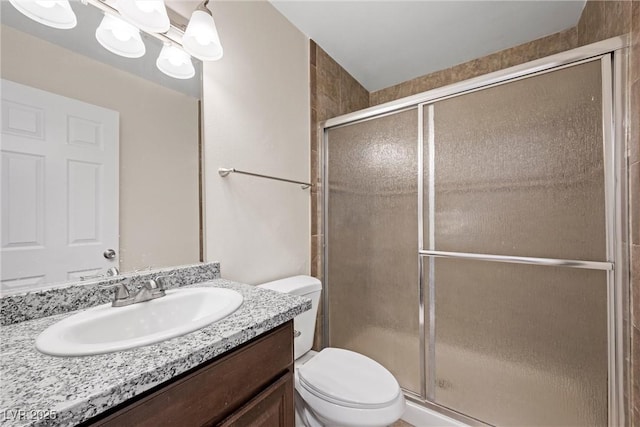 full bath featuring vanity, a shower stall, toilet, and a notable chandelier