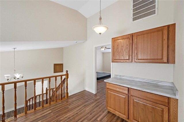 kitchen featuring dark wood-style floors, brown cabinetry, visible vents, and decorative light fixtures