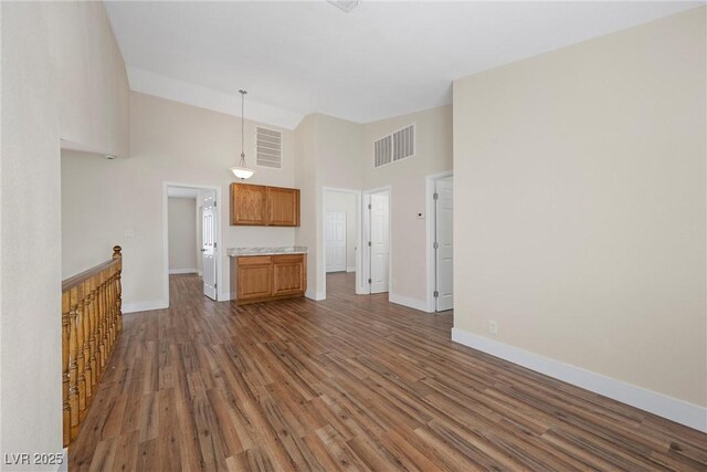 unfurnished living room featuring dark wood-type flooring, visible vents, high vaulted ceiling, and baseboards