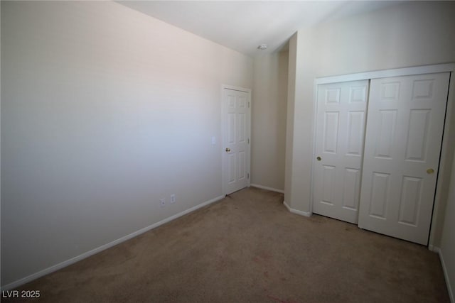 unfurnished bedroom featuring a closet, baseboards, and carpet flooring