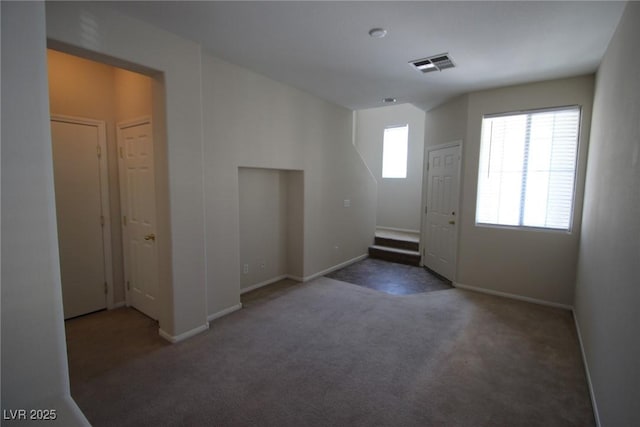 interior space featuring visible vents, dark carpet, and baseboards