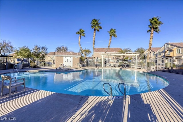 community pool with a patio area, fence, and a pergola