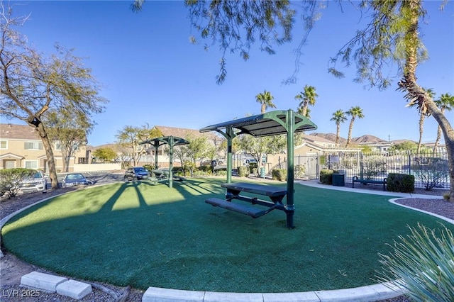 view of property's community featuring a yard, a residential view, and fence