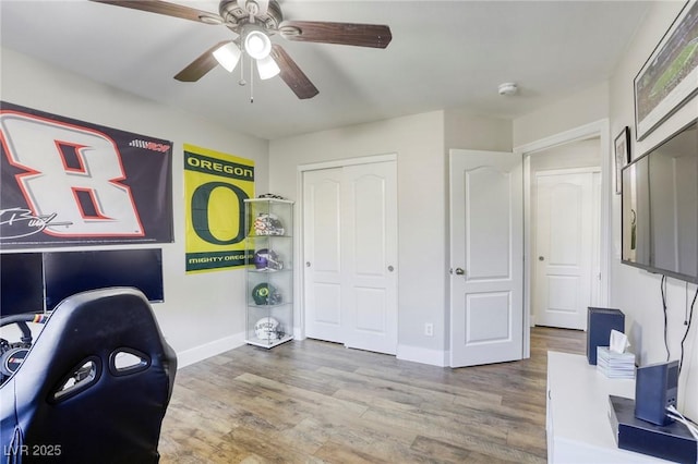 office area featuring a ceiling fan, baseboards, and wood finished floors