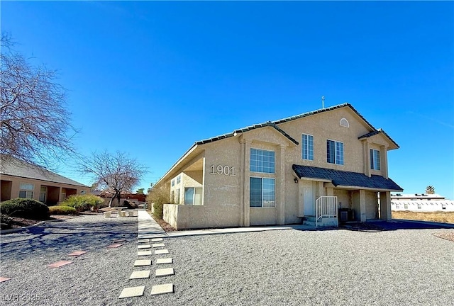 rear view of property featuring stucco siding