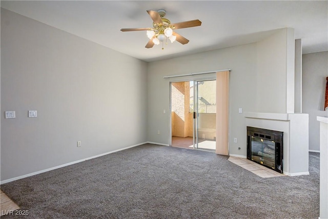 unfurnished living room featuring carpet floors, a fireplace with flush hearth, a ceiling fan, and baseboards