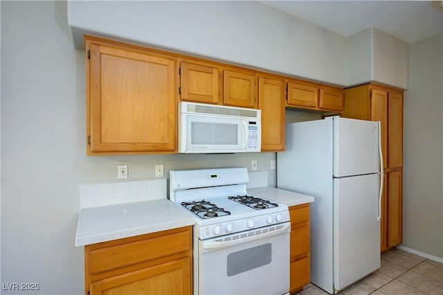 kitchen featuring white appliances, light countertops, and light tile patterned floors