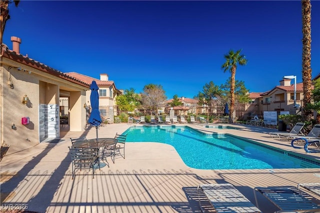 pool with a patio and fence