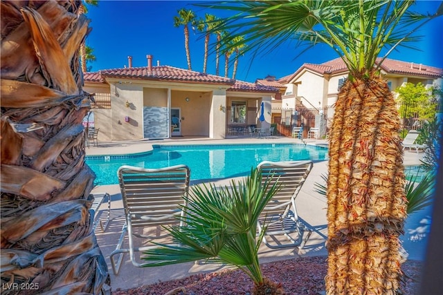 pool with a patio and fence