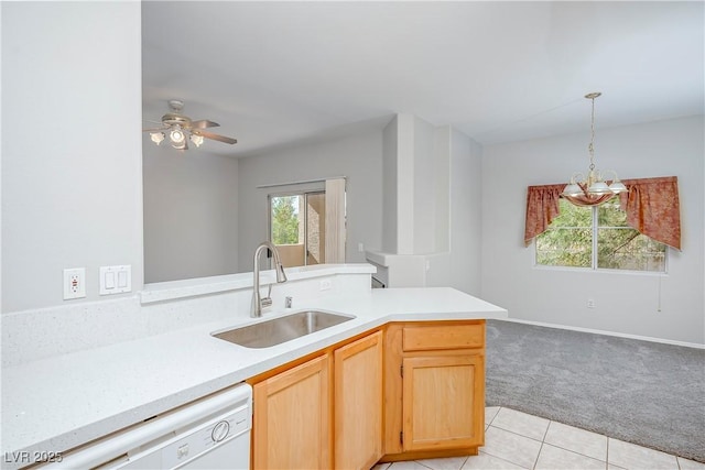 kitchen with decorative light fixtures, light countertops, light colored carpet, a sink, and dishwasher