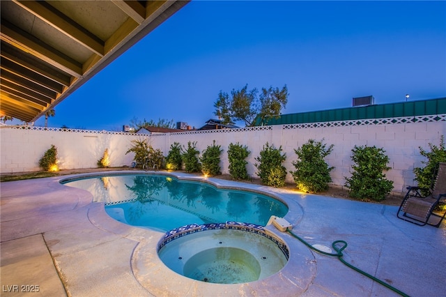 view of swimming pool featuring a pool with connected hot tub, a fenced backyard, and a patio