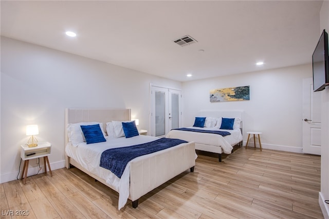 bedroom featuring light wood-type flooring, french doors, visible vents, and baseboards