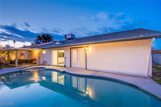 view of pool with a pool with connected hot tub, a patio area, and central AC