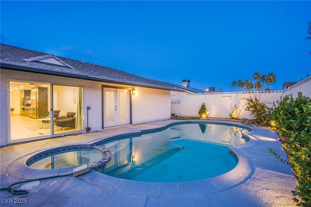 view of pool featuring french doors, a patio area, a fenced backyard, and a pool with connected hot tub