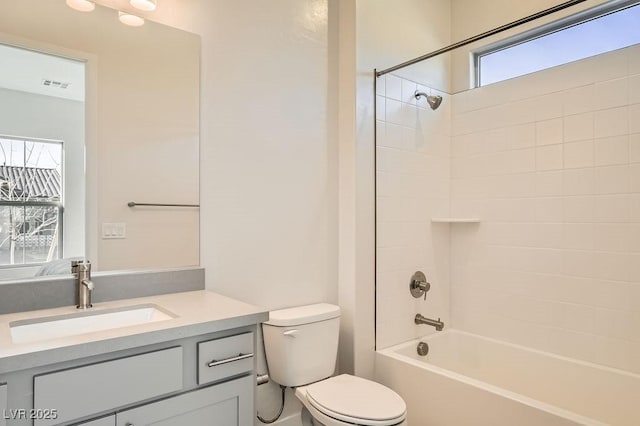 bathroom with visible vents, vanity, shower / tub combination, and toilet