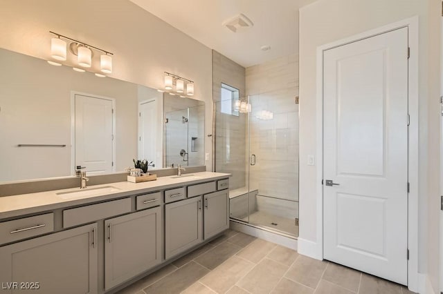 full bathroom with double vanity, a shower stall, a sink, and tile patterned floors