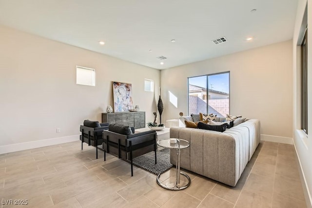 living area with baseboards, visible vents, and recessed lighting