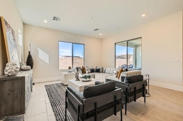 living room with recessed lighting, visible vents, and baseboards