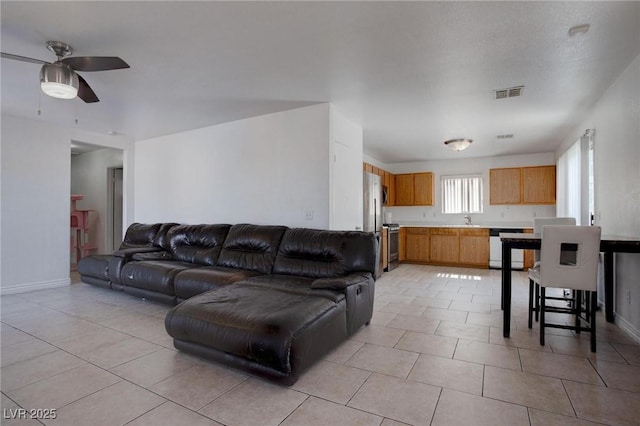 living area with a ceiling fan, visible vents, and light tile patterned floors