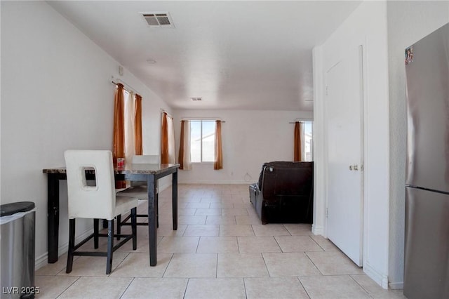 dining space featuring baseboards, visible vents, and light tile patterned flooring